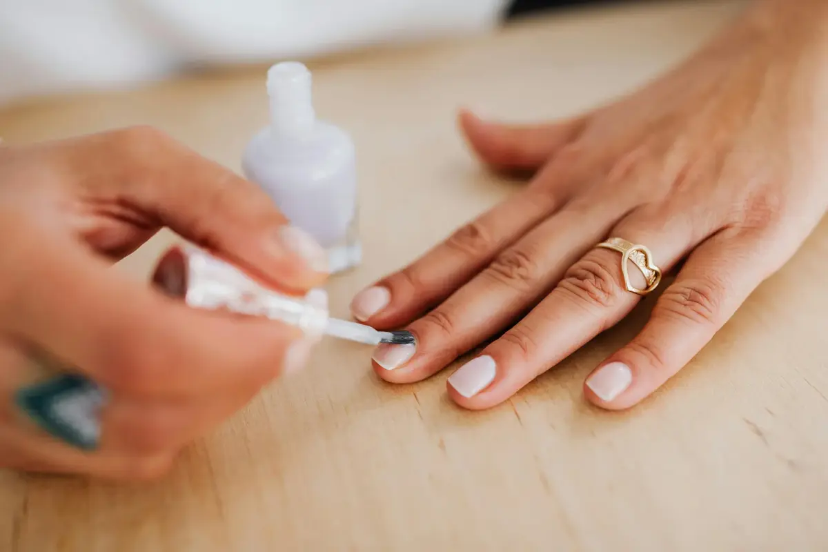 Nahaufnahme einer Hand mit Nagellack – Symbolbild für brüchige Nägel Ursache