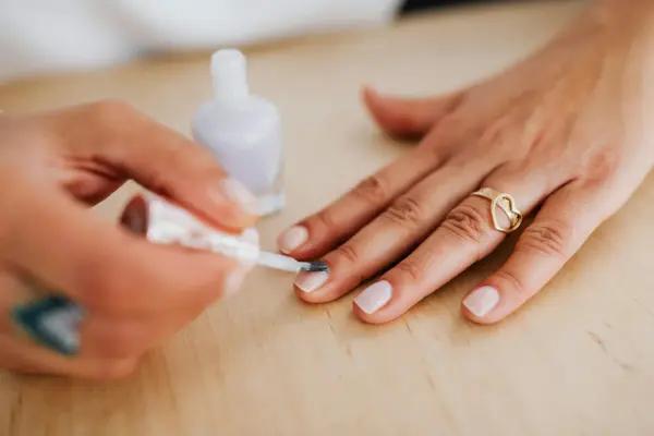 Nahaufnahme einer Hand mit Nagellack – Symbolbild für brüchige Nägel Ursache