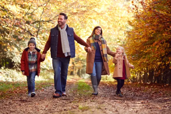 Familie spaziert im bunten Herbstwald zur Stärkung von Gesundheit und Immunsystem
